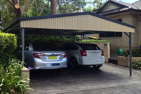 Two cars parked under double gable roof carport in blue and cream