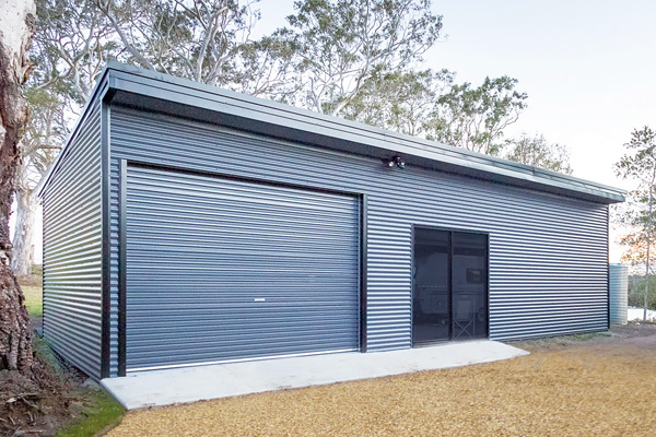 Monopitch roof shed with eaves with single roller door and sliding glass access door 