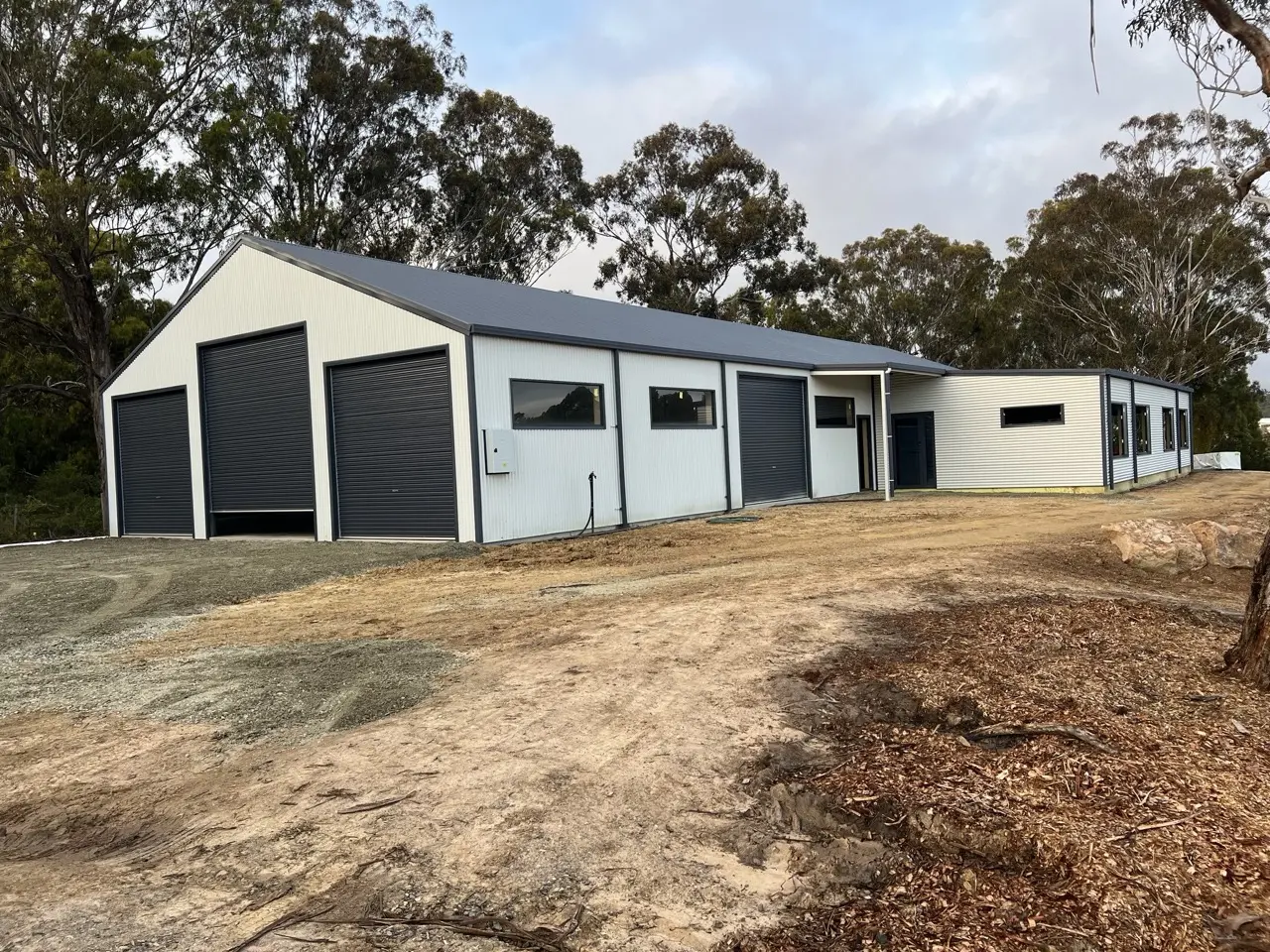 12 x 32 shedhouse to lockup stage, 22 deg roof pitch, 6 x 16 left lean to, 13 custom windows, 5 roller doors, 1 PA door, fully insulated, Colourbond®  Ironstone®  and Surfmist®  Large