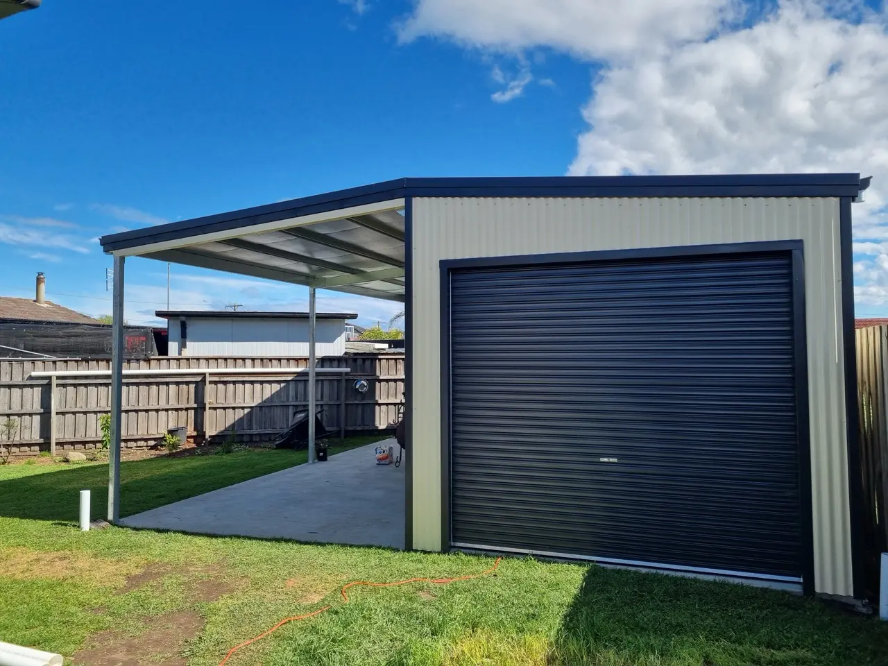 3.5 x 8 shed with left lean to 3.5x 8. 5 deg roof pitch, 2 roller doors, 2 PA doors, 1 window, COLORBOND® Classic Cream®  and Monument®    Large