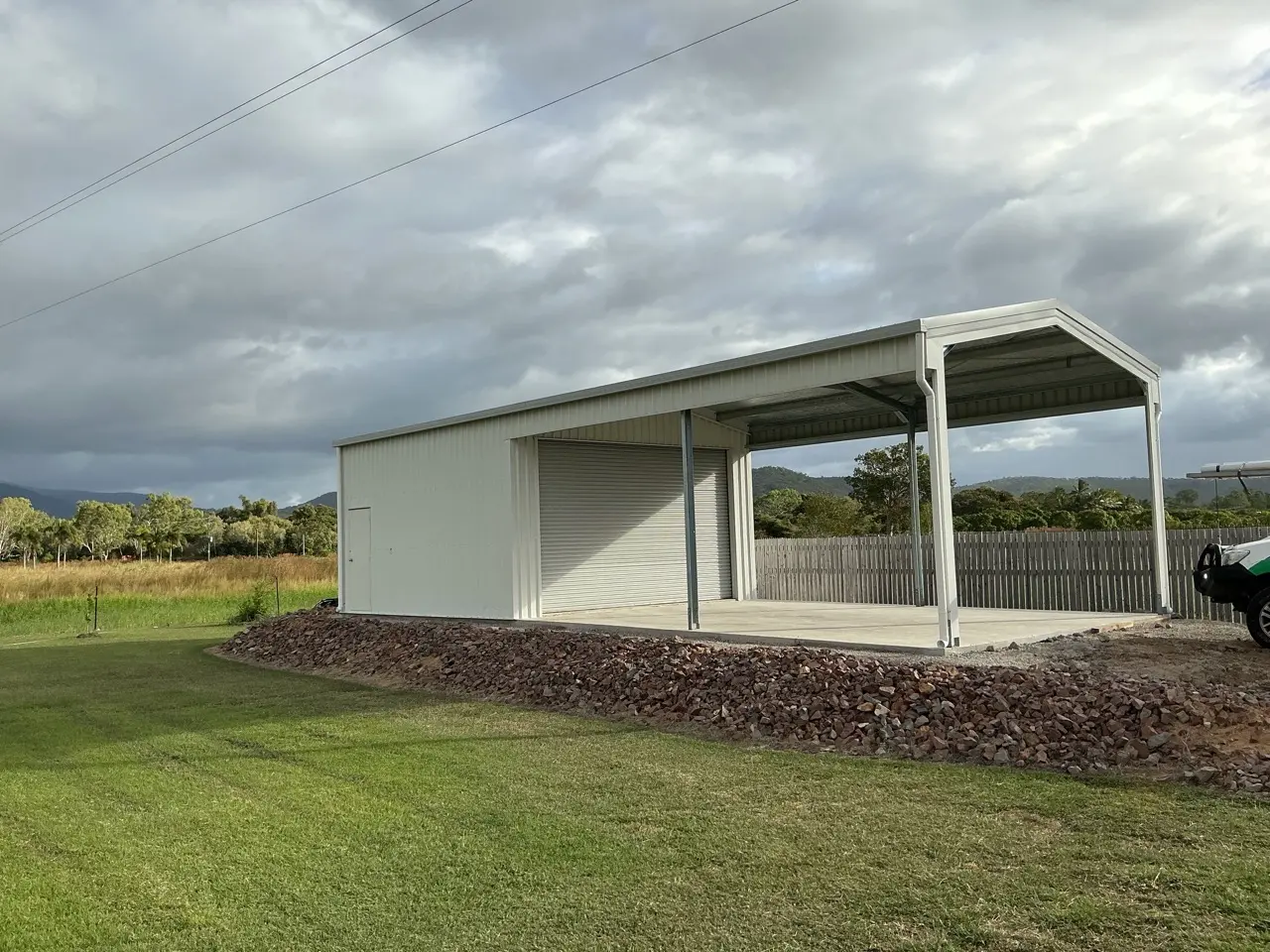 Side view of shed with open carport bay