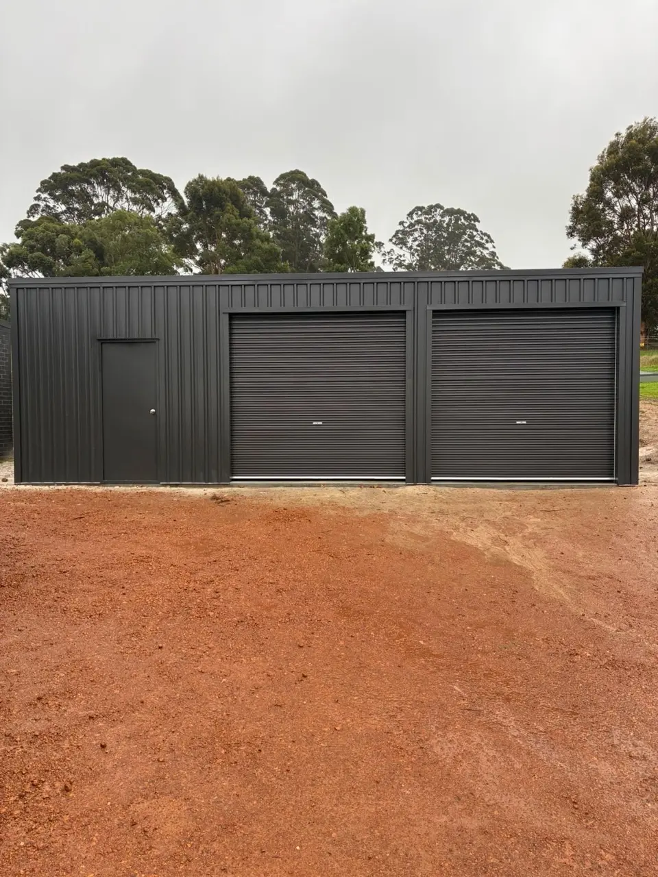 Front view of black double roller door shed